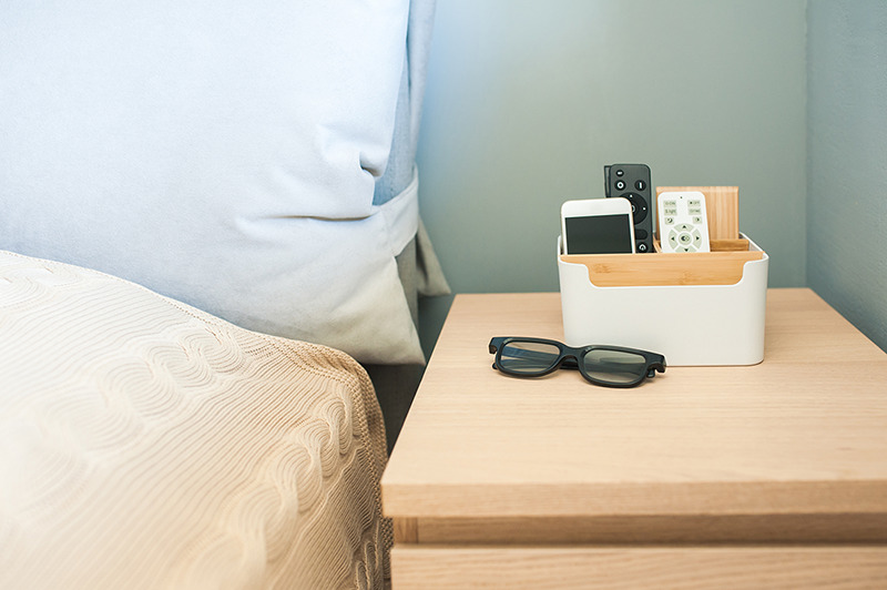 phone in organizer on nightstand next to bed