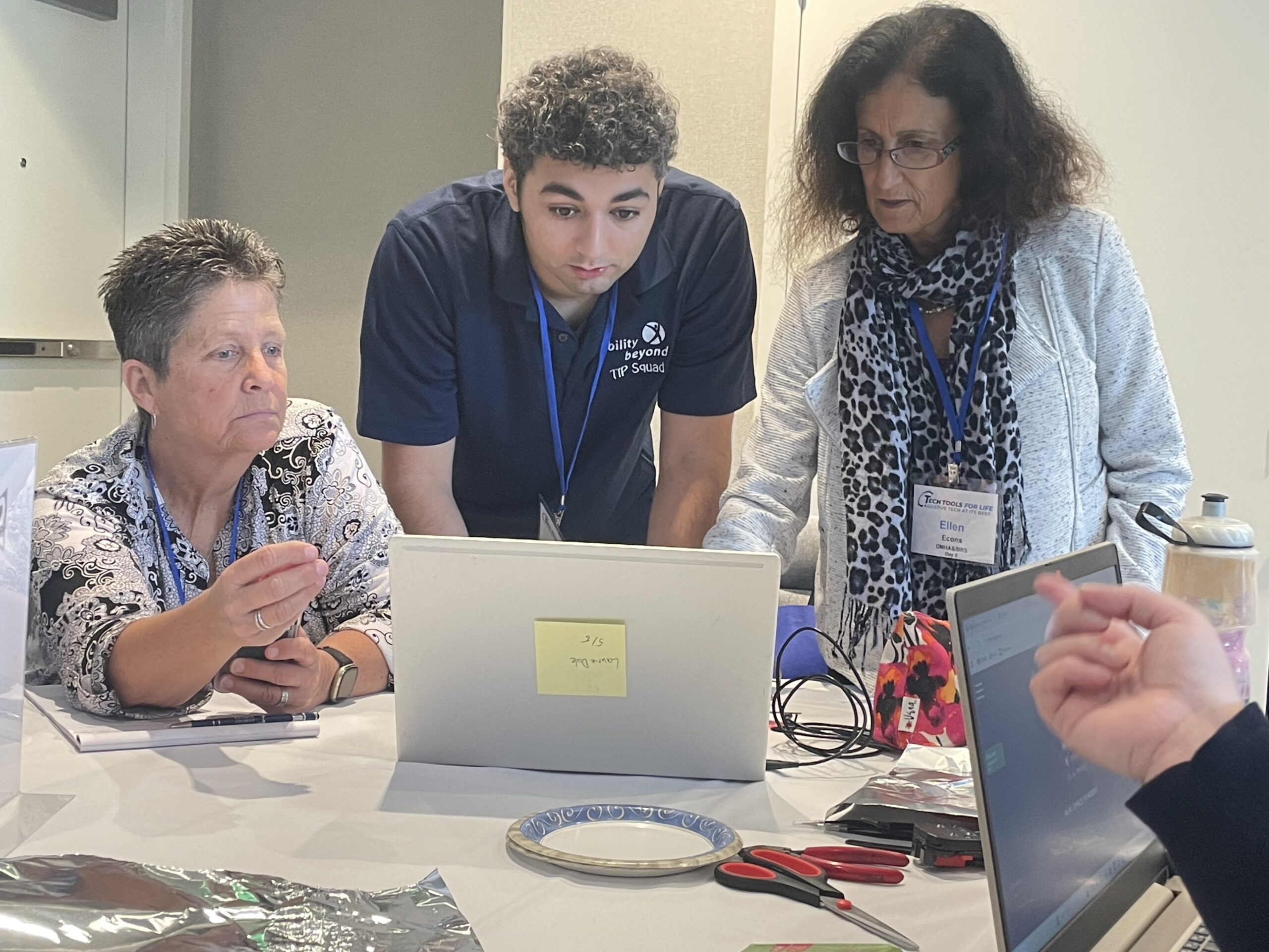 Peter, a member of the TIP Squad, shows participants of a recent assistive technology conference how to make a simple switch.